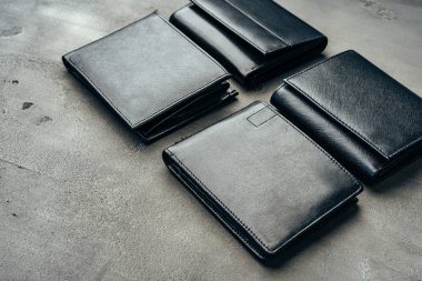 Gri beton arka planda erkek deri cüzdanları