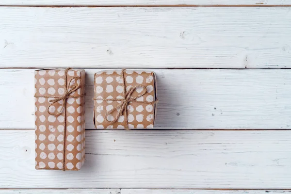 Regalos de Navidad envueltos en tablero de madera blanco, vista superior —  Fotos de Stock