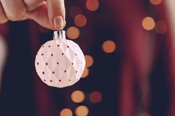 Mano femenina sosteniendo una bola de Navidad de cerca — Foto de Stock