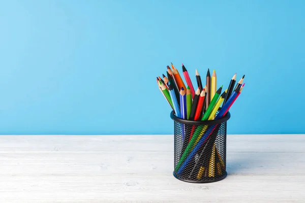Forniture scolastiche su scrivania in legno su sfondo blu — Foto Stock