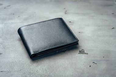 Gri beton arka planda siyah deri cüzdan