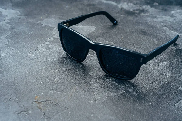 Gafas de sol masculinas oscuras sobre superficie de hormigón gris —  Fotos de Stock