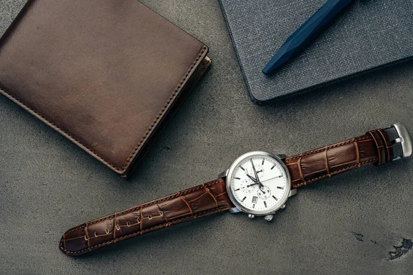 Mężczyzna zegarek i skórzany portfel na ciemnoszarej powierzchni — Zdjęcie stockowe