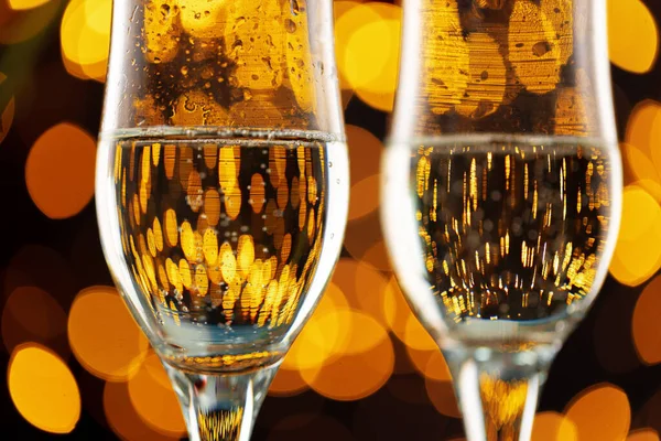Dos copas de champán contra fondo de luces bokeh — Foto de Stock