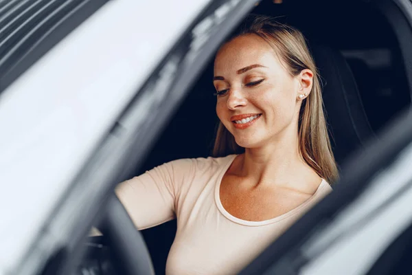 Junge attraktive Kaukasierin sitzt in ihrem neu gekauften Auto — Stockfoto