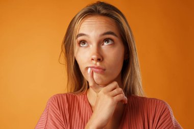 Sıradan düşünen güzel bir genç kadının stüdyo portresi.