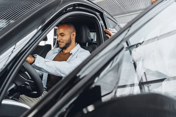 Jovem atraente mulher vendedor no carro showroom mostrando um carro para seu cliente masculino — Fotografia de Stock