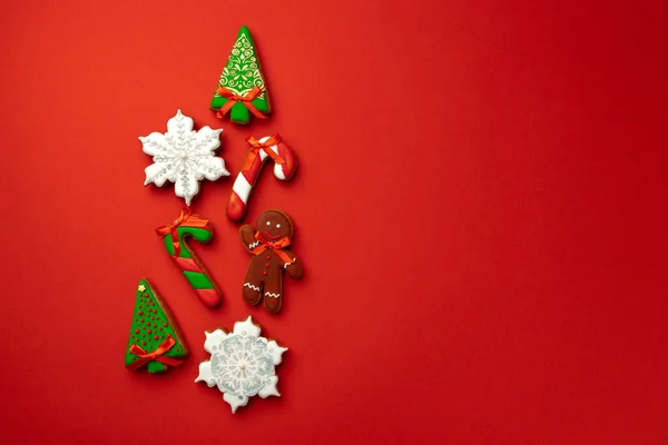 Perníkové sušenky pro vánoční oslavu na červeném pozadí — Stock fotografie