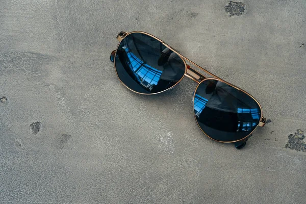 Gri beton arka planda yeni koyu renk havacı gözlükleri — Stok fotoğraf
