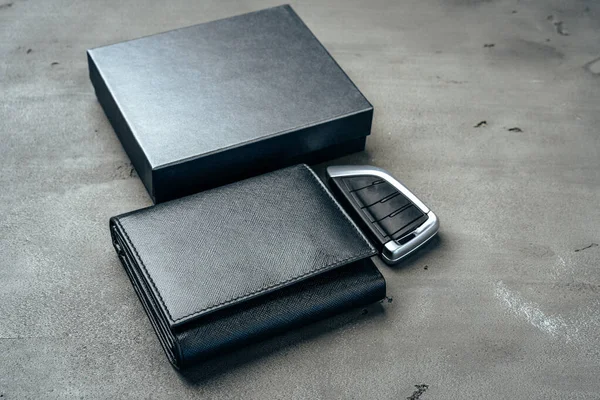 Billetera de cuero masculino y llave del coche sobre fondo gris oscuro — Foto de Stock