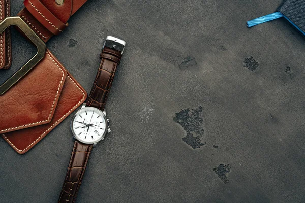 Ανδρικό ρολόι και δερμάτινο πορτοφόλι σε σκούρο γκρι επιφάνεια — Φωτογραφία Αρχείου