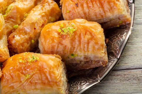 Delicious baklava dessert in oriental bronze setting close up — Stock Photo, Image