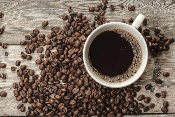 Tasse de café et haricots sur fond en bois. Photo de haute qualité — Photo