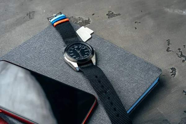 Heren accessoires zoals smartphone en horloge op donkergrijze tafel — Stockfoto