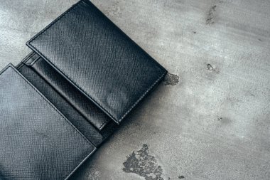 Gri beton arka planda siyah deri cüzdan