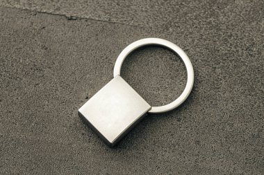 Koyu beton arkaplanda metal anahtar kolyesi