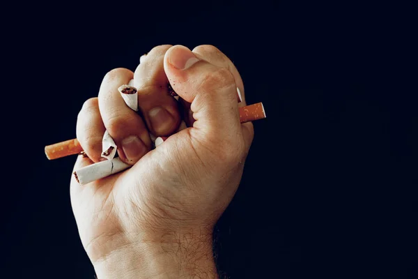 Чоловіча рука розбиває сигарети крупним планом — стокове фото