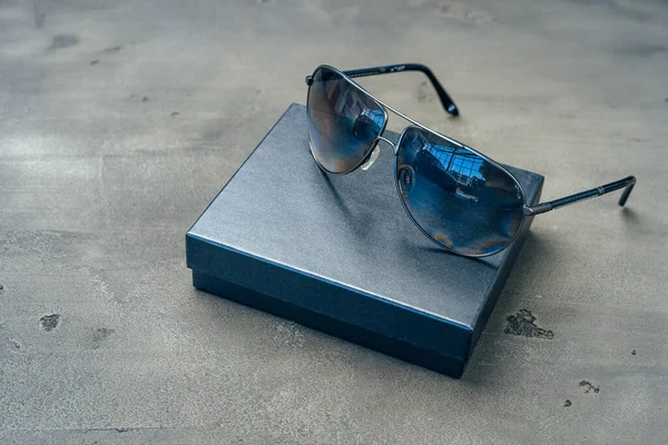 Nuovi occhiali aviatore scuro su sfondo grigio cemento — Foto Stock