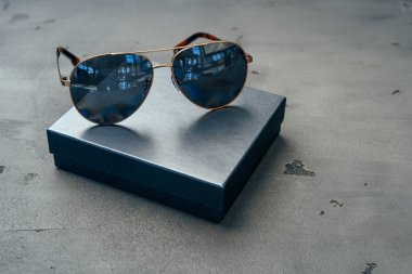 Gri beton arka planda yeni koyu renk havacı gözlükleri