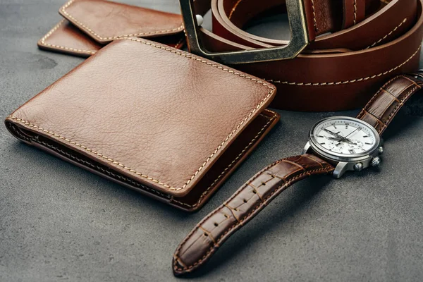Man klocka och läder plånbok på mörkgrå yta — Stockfoto