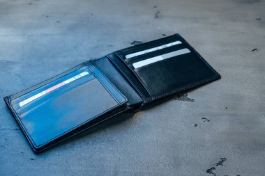 Gri beton arka planda siyah deri cüzdan