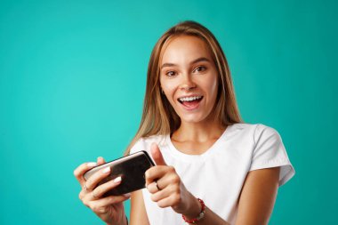 Gülümseyen ve video görüşmesi yapan mutlu bir genç kadın.