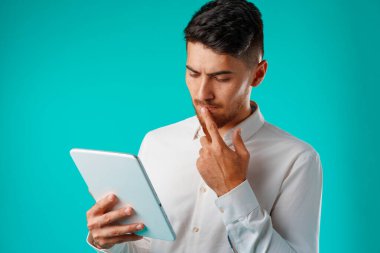 Beyaz gömlekli genç işadamı dijital tablet tutuyor