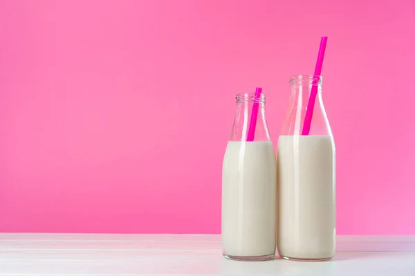 Deux bouteilles de lait ou milkshake en verre sur fond rose — Photo