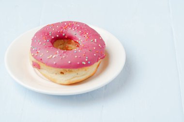 Kaplamalı donut, tabağa serpiştirilmiş. Yaklaş.