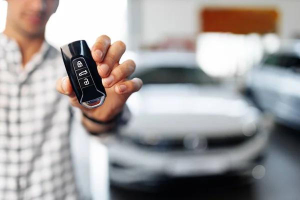 Yeni lüks arabaya karşı arabanın anahtarlarını gösteren bir erkek. — Stok fotoğraf