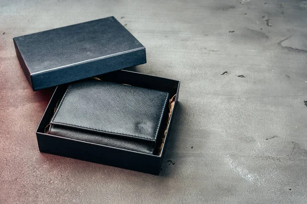 Portafogli in pelle nera su sfondo grigio cemento — Foto Stock