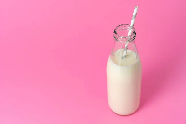 Botella de vidrio de leche sobre fondo rosa —  Fotos de Stock