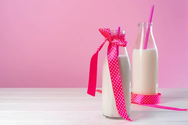粉红背景下的两瓶牛奶或奶昔 — 图库照片