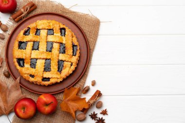 Kuru yapraklar ve tarçın çubuklarıyla süslenmiş beyaz tahta üzerinde sonbahar teşekkür pastası.