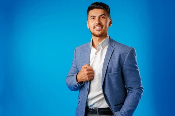 Portrait of a young mixed race businessman against blue background — Stock Photo, Image