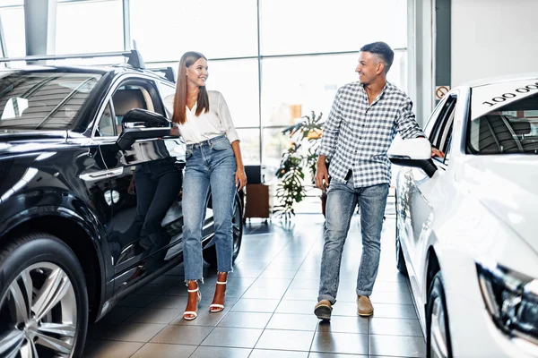 Mladý pár vybírá své nové auto v obchodě s auty — Stock fotografie