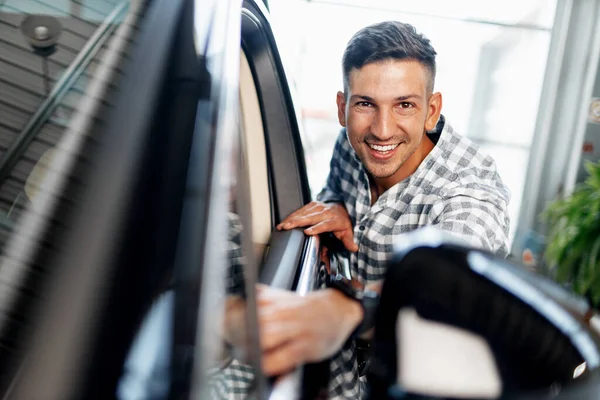 Joyeux jeune homme client achète une nouvelle voiture dans un concessionnaire — Photo