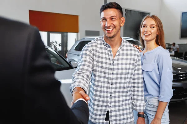 Pečlivý mladý pár v prodejně kupovat nové auto — Stock fotografie