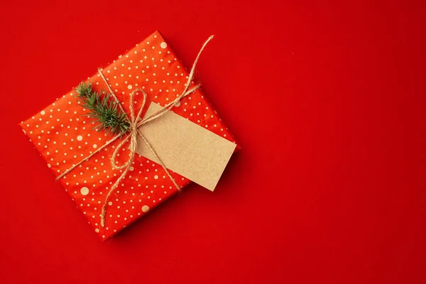 Hoja de papel en blanco y regalo envuelto para la celebración de Navidad sobre fondo rojo — Foto de Stock