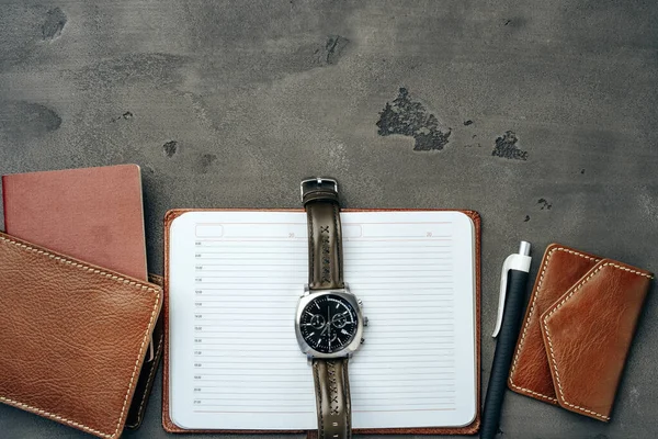 Businessmans tillbehör, inklusive anteckningsblock, klocka och väska på mörkgrå bakgrund — Stockfoto