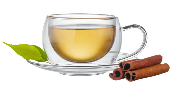 Xícara de vidro de chá e canela varas isoladas em branco — Fotografia de Stock