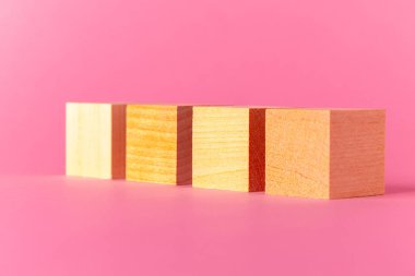 Pembe arkaplana karşı kopyalama alanı olan oyuncak tahta küpler