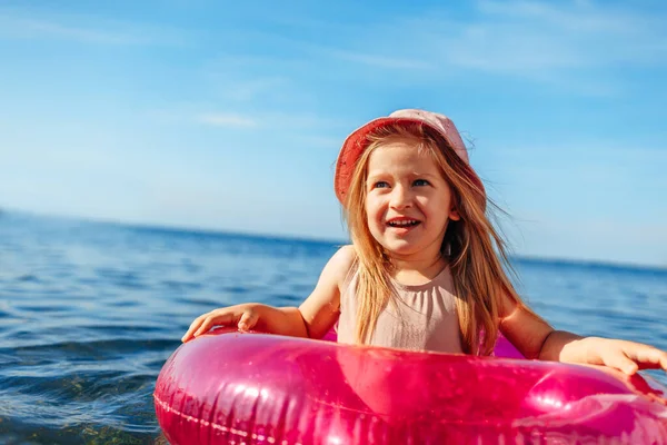 Jeune fille en panama rose nageant dans la mer avec cercle — Photo