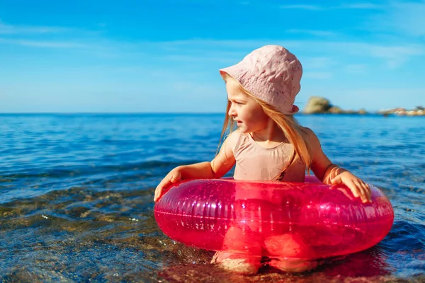 Bonne petite fille se baignant dans la mer avec cercle rose — Photo