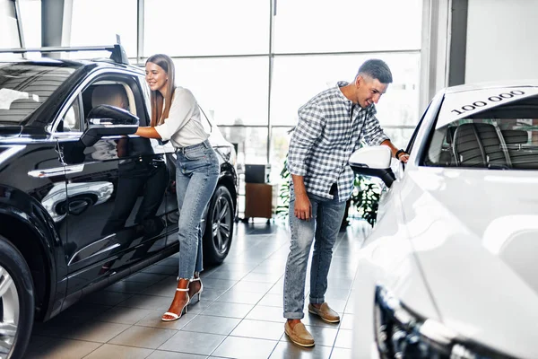 Mladý pár vybírá své nové auto v obchodě s auty — Stock fotografie