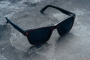 Koyu erkek güneş gözlükleri gri beton yüzeyde