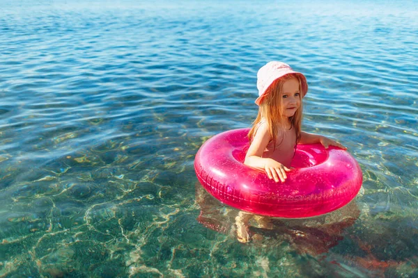 Bonne petite fille se baignant dans la mer avec cercle rose — Photo