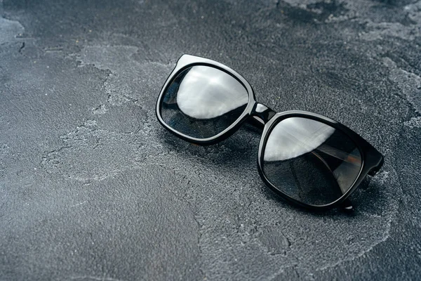 Occhiali da sole maschili scuri su superficie in cemento grigio — Foto Stock