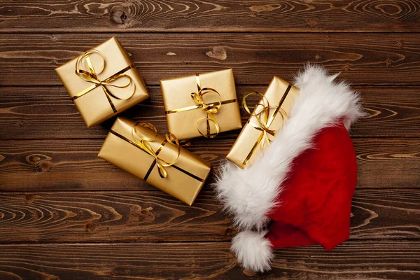 Санта-капелюх і загорнуті подарункові коробки вид зверху — стокове фото