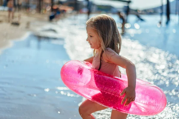 Petite fille avec cercle gonflable rose se baignant dans la mer — Photo